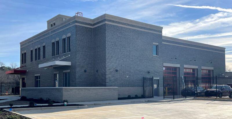 Fire station 1 diagonal view of gated parking lot and side of building