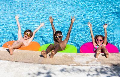 kids at pool 3 children in tubes in a pool