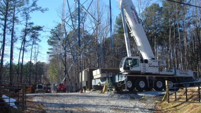 A crane in front of a radio tower