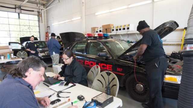 Employees servicing radio equipment for police cruisers
