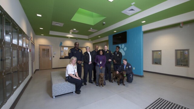 A crowd of people and 2 dogs in the Animal Center lobby