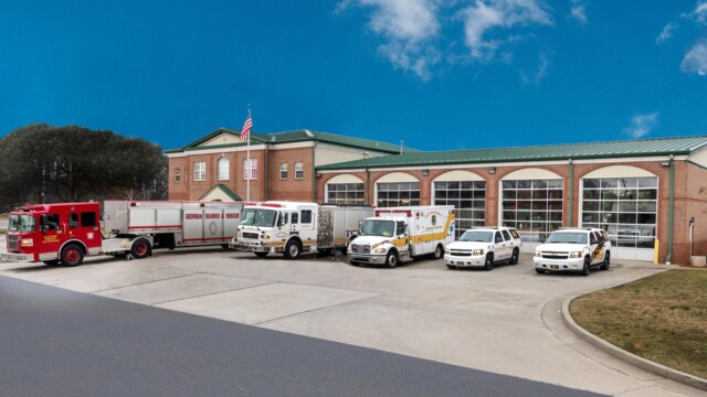 Georgia Search and Rescue truck, fire truck, ambulance, and 2 cars parked in front of fire station