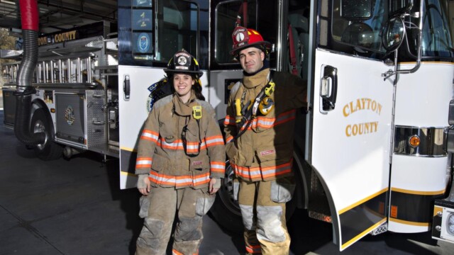 2 firefighters outside of truck with door opened
