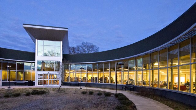 Forest Park Library outside at night with lights on inside
