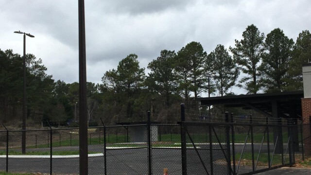 fenced off parking lot in rear of building