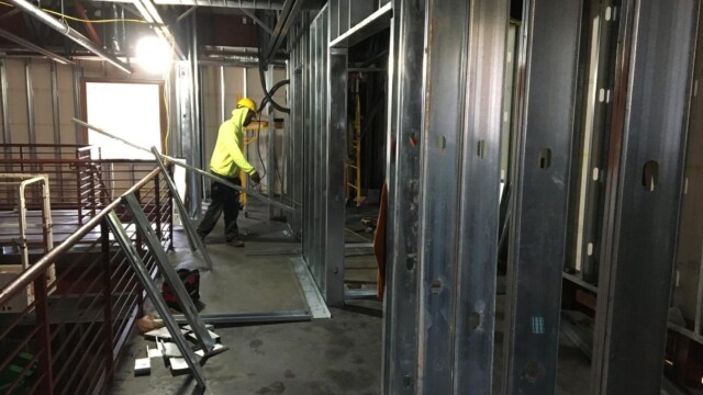 Construction worker moving structural metal beams