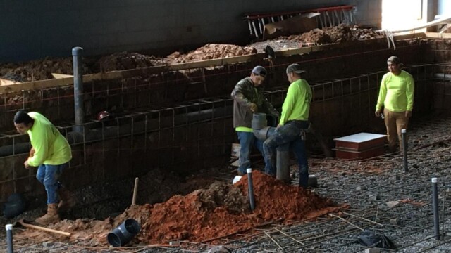 men working on piping inside new pool area