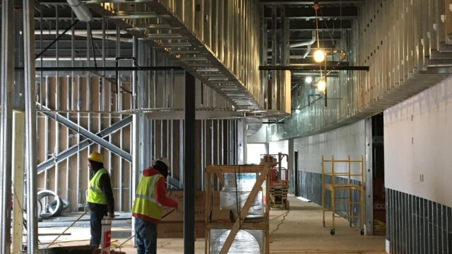 inside under construction with 2 construction workers