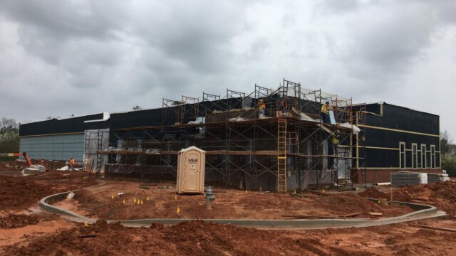 building under construction with scaffolding and port-a-potty up front