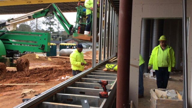 Construction workers building out a wall