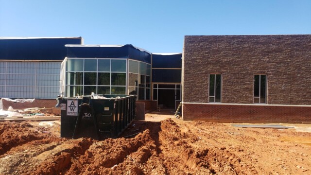 building under construction with dumpster in front