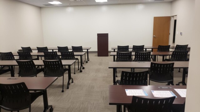 room with podium in middle and tables and chairs in front