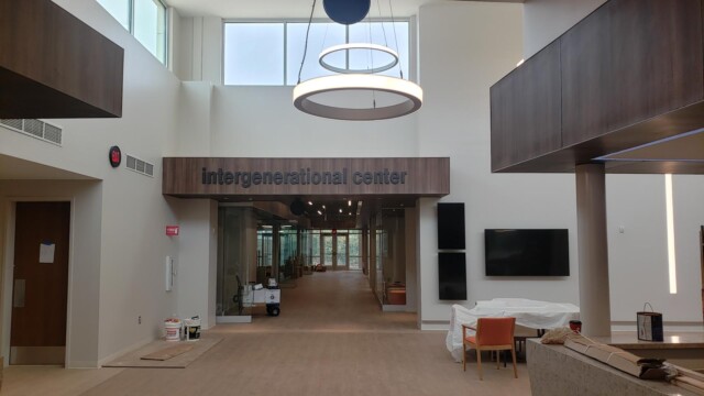 integenerational center signage in interior with TVs mounted on wall