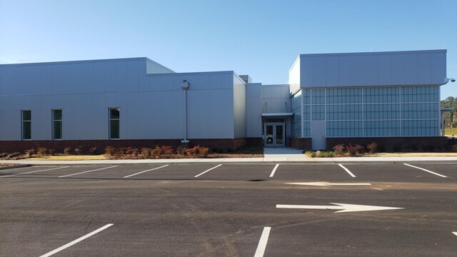 side view of building with double doors in front of new parking lot