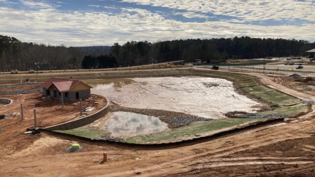 An artificial lake with mud in it, on a partly sunny day