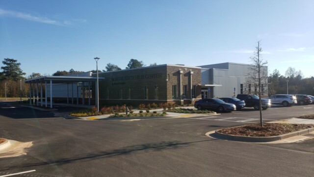 senior center from corner side with cars in parking lot with cars parked along side of building