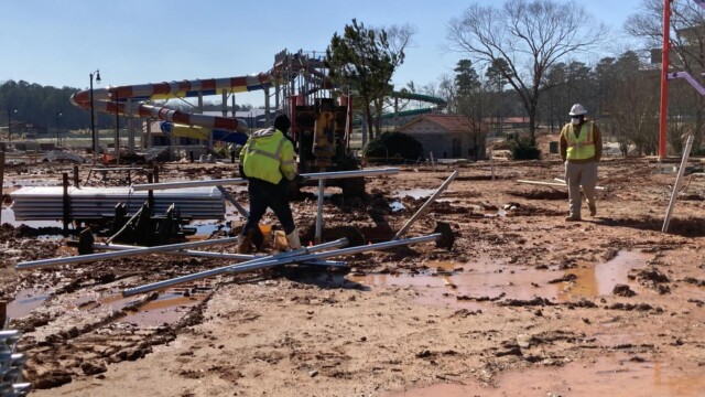 workers moving metal piping