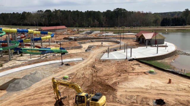 Excavator on dirt nearby water park