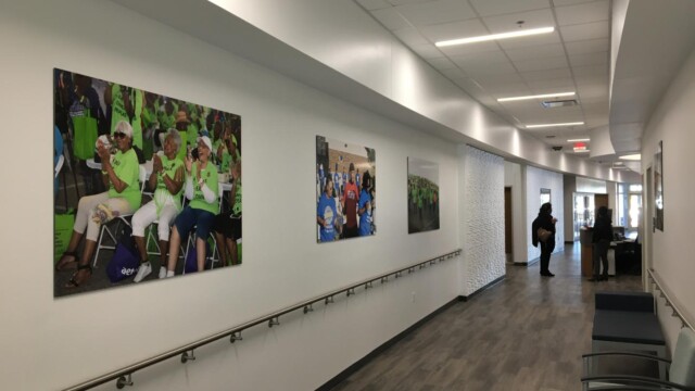 view of hallway with images of seniors on the walls and 2 ladies talking at the end