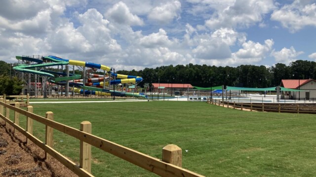 Wooden fencing surrounding grass around the water park