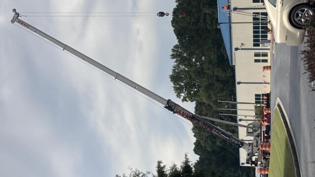 Mobile Crane adding materials to top of Jim Huie Roof