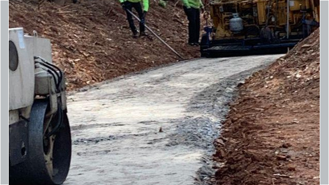 truck coming down path with workers smoothing where it goes