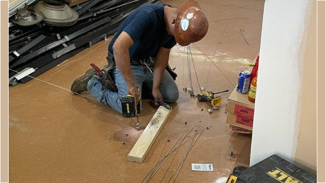 A worker drilling into the floor