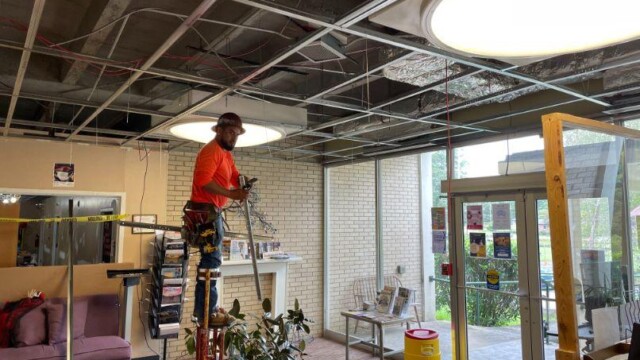 Worker on stilts working on the ceiling above