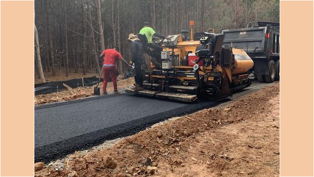 men smoothing out the fresh asphalt