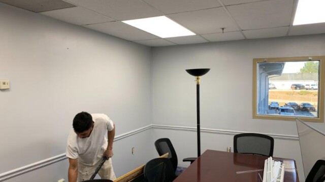 Man cleaning the floors in office room