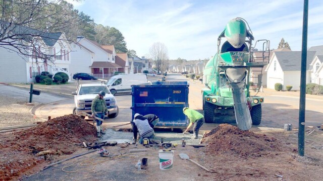 workers pouring concrete at the very beginning of path in the neighborhood