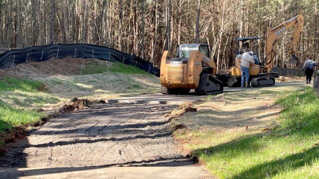 forklift moving dirt along the trail
