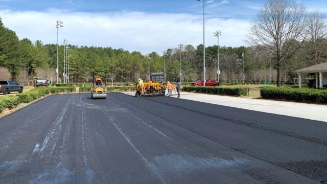 Construction crew resurfacing tennis courts