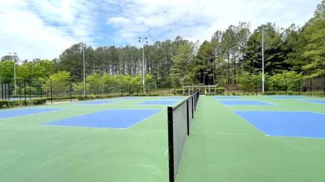 A divider fence between tennis courts