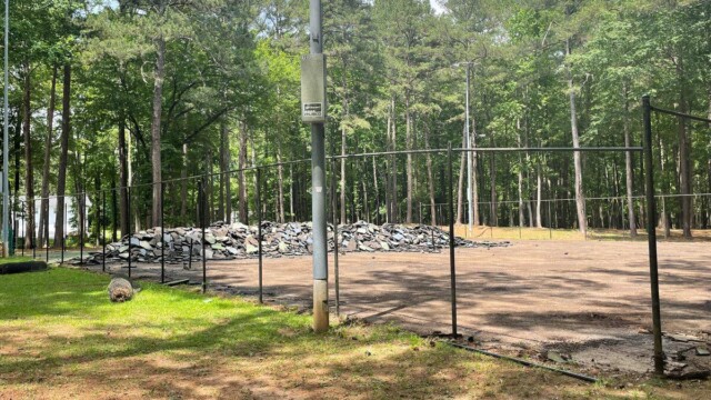 Fencerail progress around a pile of old court surface debris at Independence Park