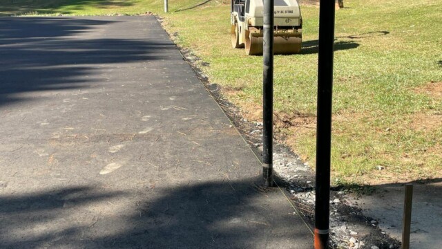 Leveled surface, with road roller parked nearby in the grass at Flat Shoals Park