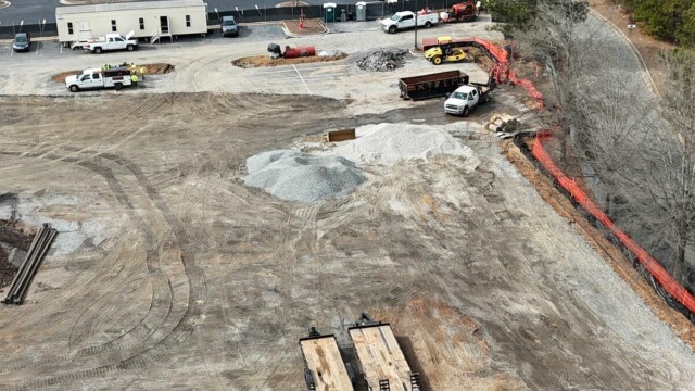 aerial view of construction site with piles of rock and trailer in background