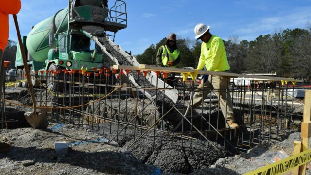 concrete being lowered as worker guides it