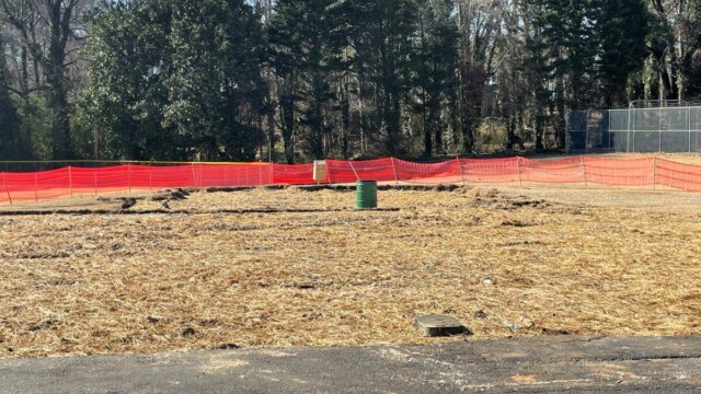 stretch of land with orange net fencing around it