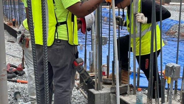 Fire Station 9 - Construction Site - Men Driving Metal Stakes Into Concrete Foundation - Clayton County Fire Station 9 - Construction Site - Men Driving Metal Stakes Into Concrete Foundation