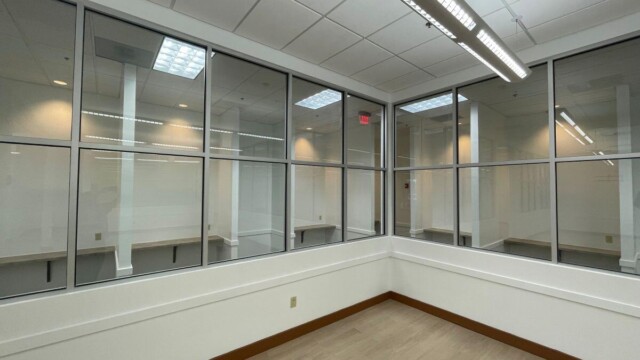 inside room with windowed walls with views of cubicles