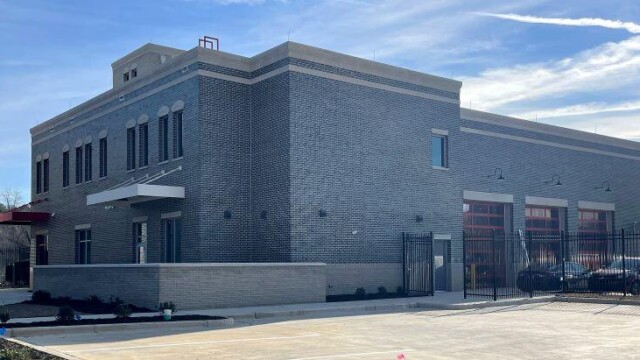 Fire station 1 diagonal view of gated parking lot and side of building